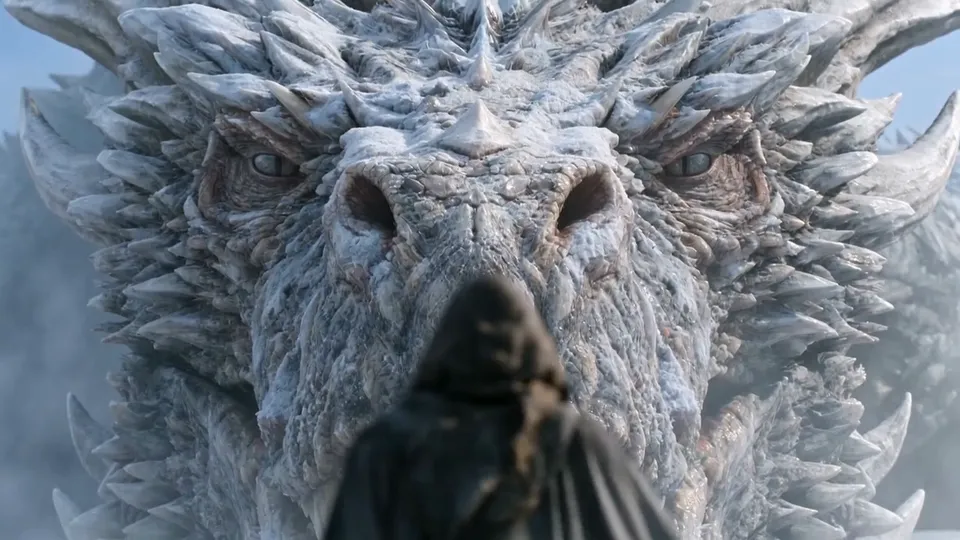 Seen over a hooded shoulder, the face of a frost dragon fills the frame
